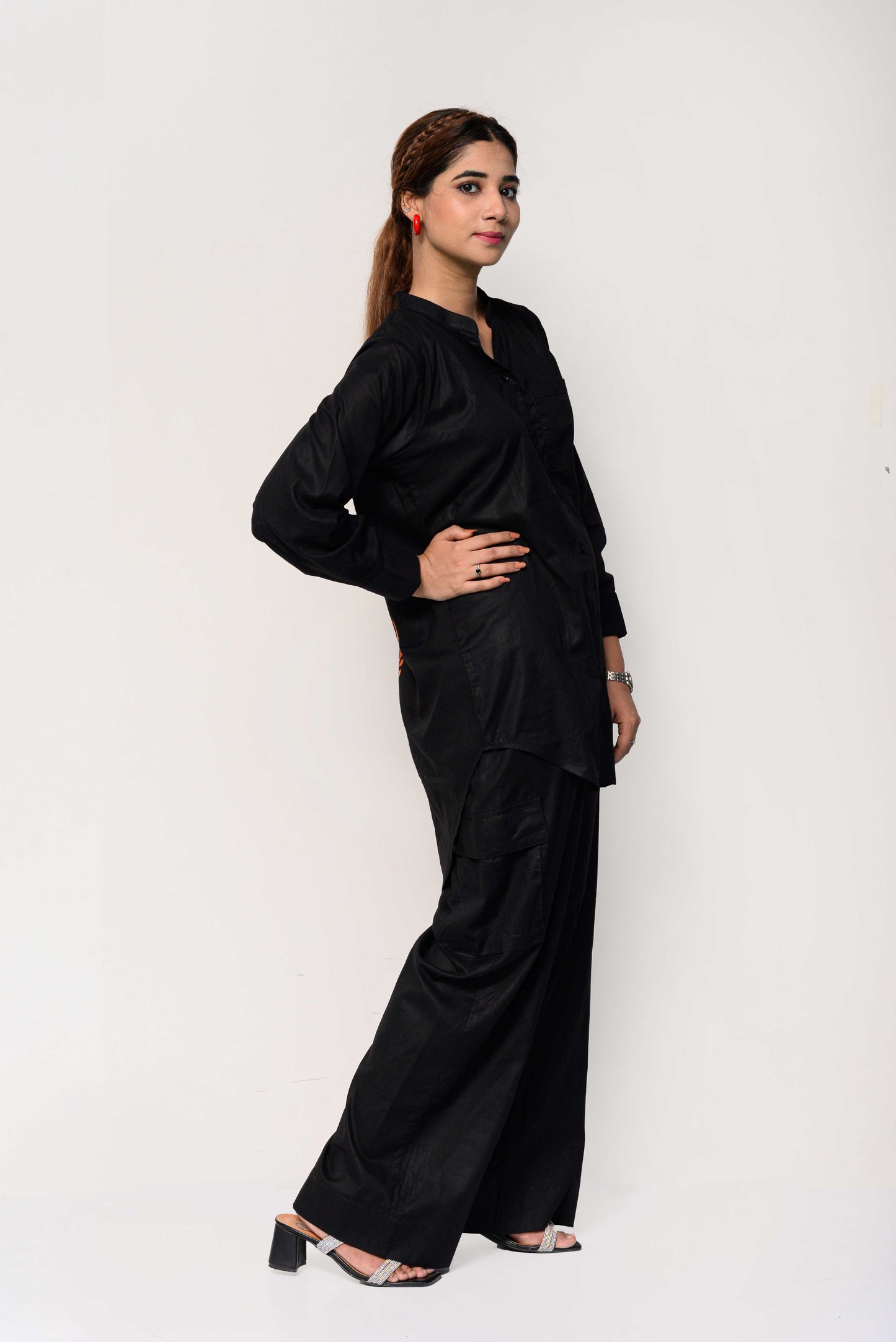 Woman wearing a black outfit with an orange palm tree design on the back against a white background