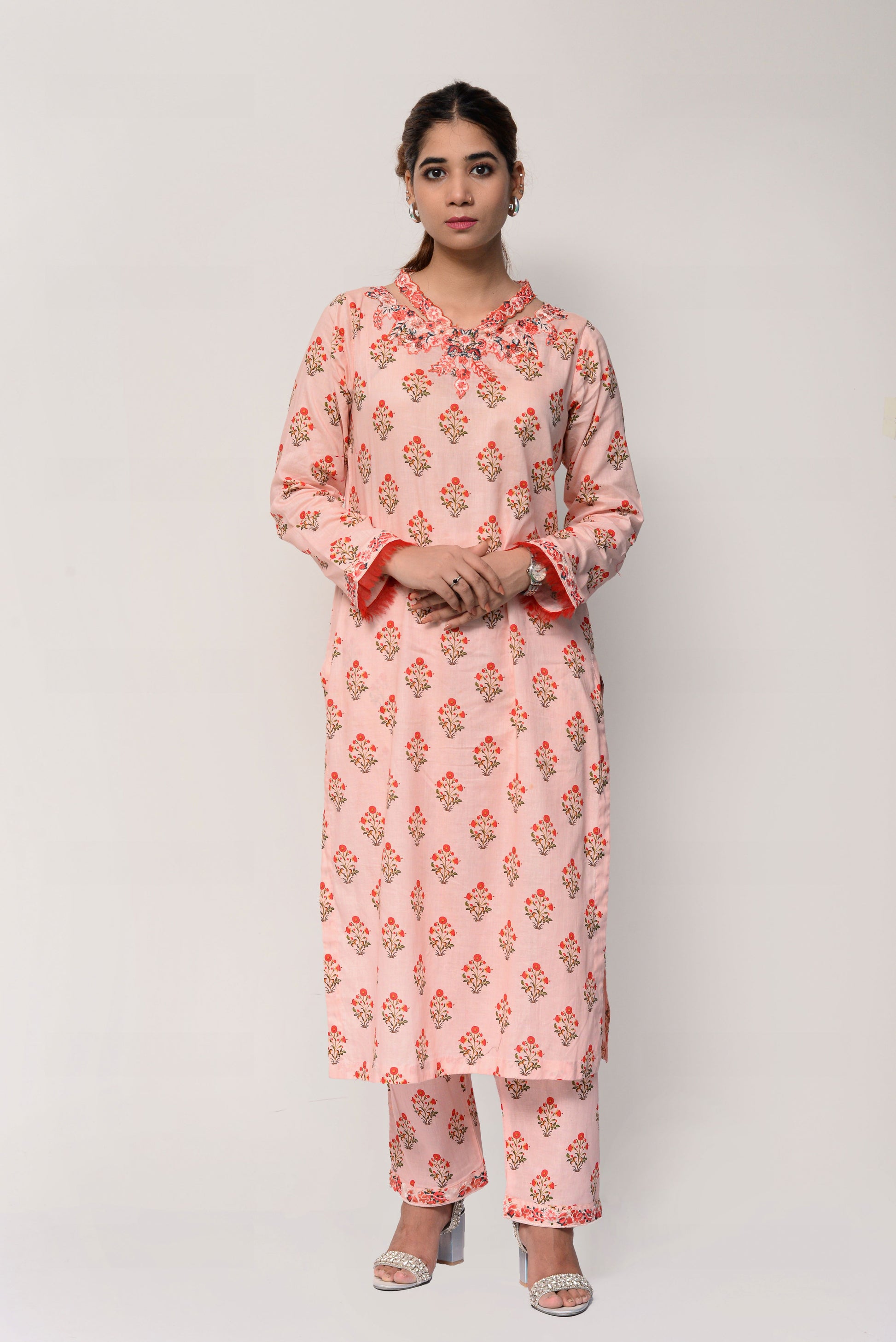 Woman wearing a pink floral kurta with pants on a white background