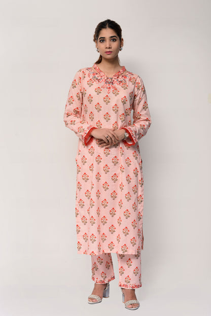 Woman wearing a pink floral kurta with pants on a white background