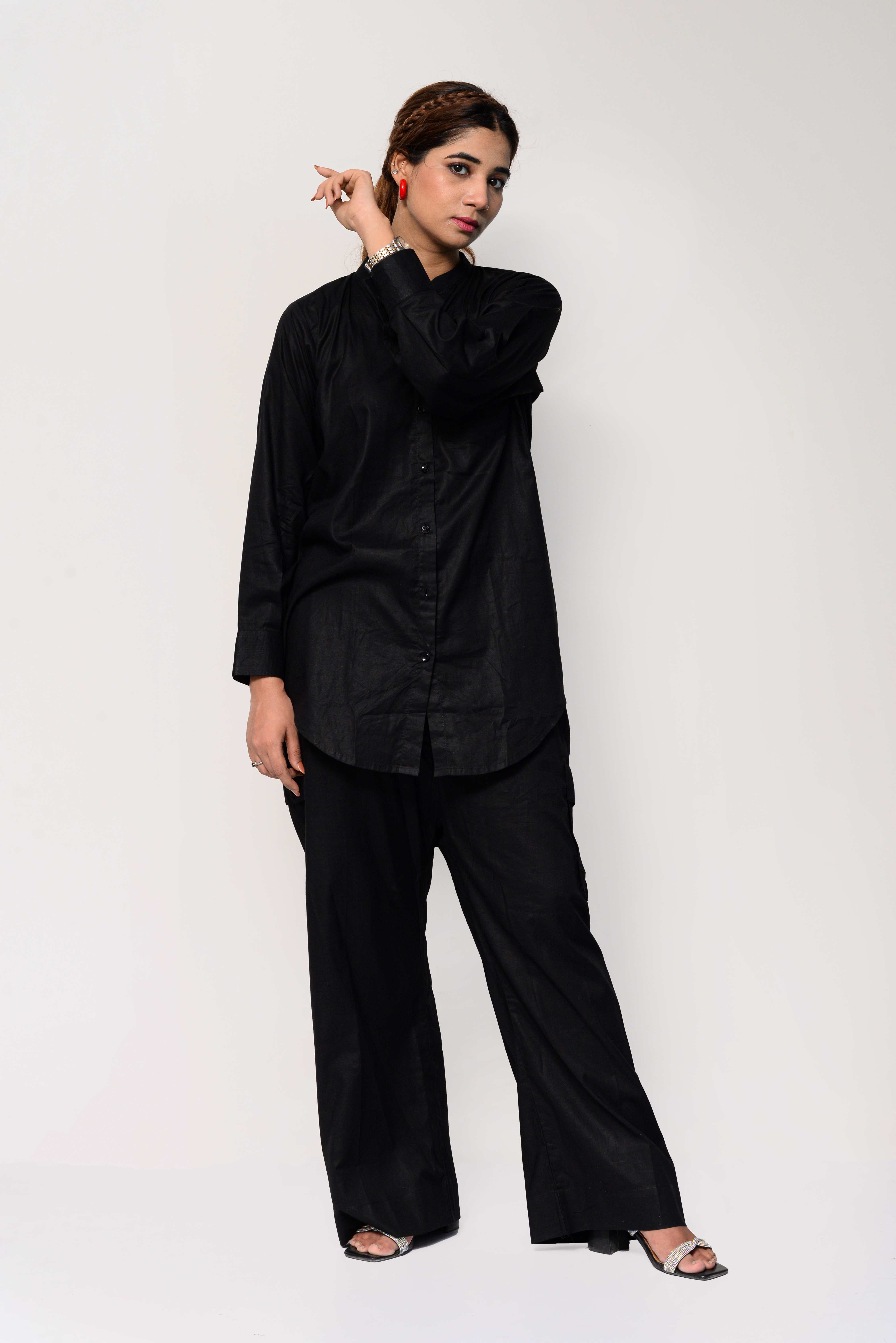 Woman wearing a black outfit with an orange palm tree design on the back against a white background